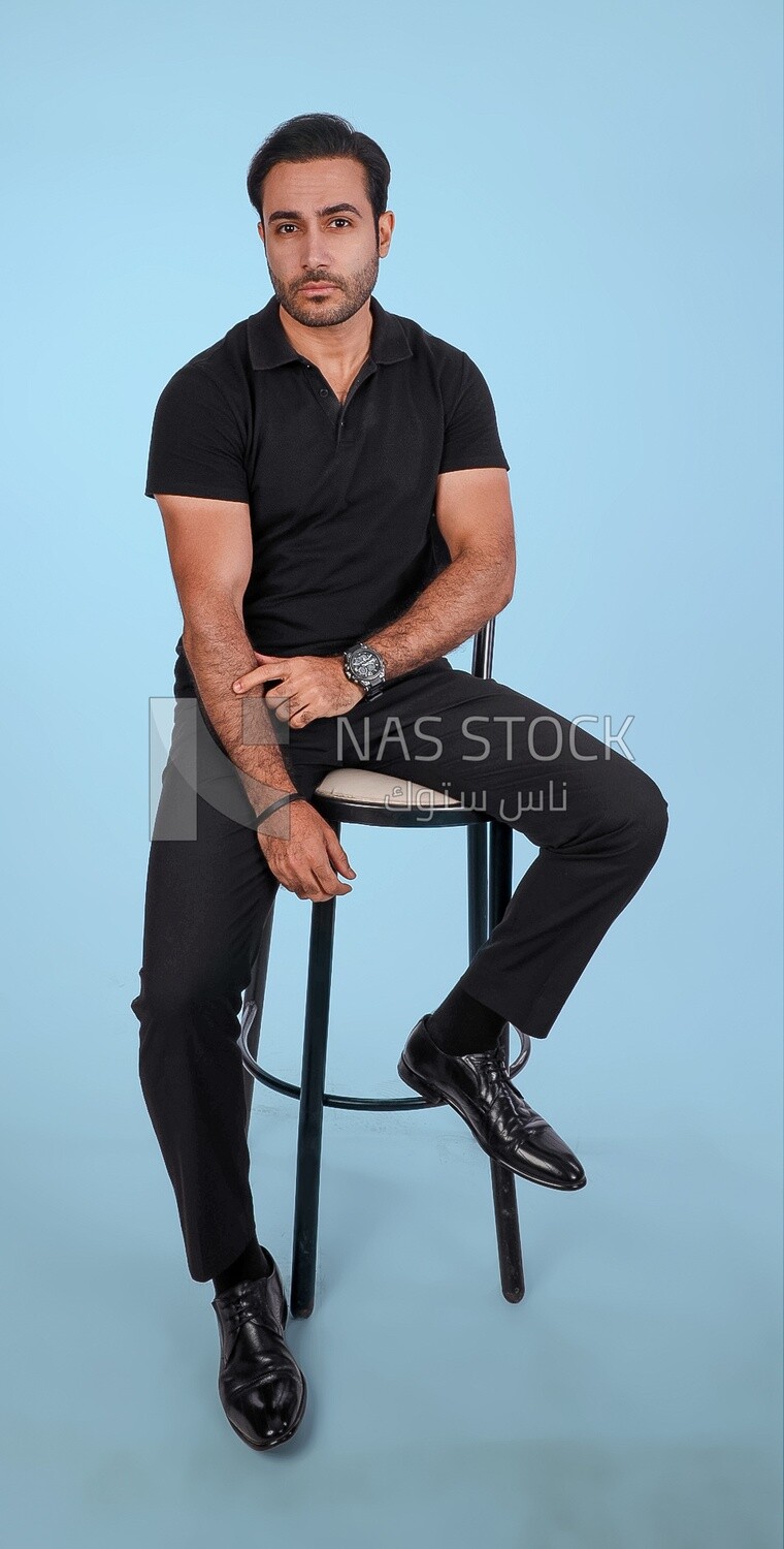 Photo Of a Handsome man sitting on the chair, Smiling Man, Wearing Casual Clothes Posing In a Light Room Interior, Smiling At the Camera