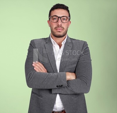 Portrait of a handsome man standing with glasses wearing formal suit with crossed hands, business development and partnerships, business meeting, Model