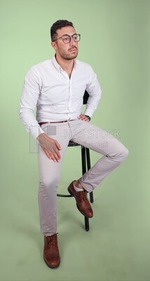 Portrait of a handsome man with glasses sitting on a chair, business development and partnerships, business meeting, Model