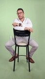 Photo of a handsome man with glasses sitting on a chair, business development and partnerships, business meeting, Model, looking away