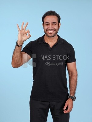 Photo Of a Handsome man Standing with hand gesture, Smiling Man, Wearing Casual Clothes Posing In a Light Room Interior, Smiling At the Camera