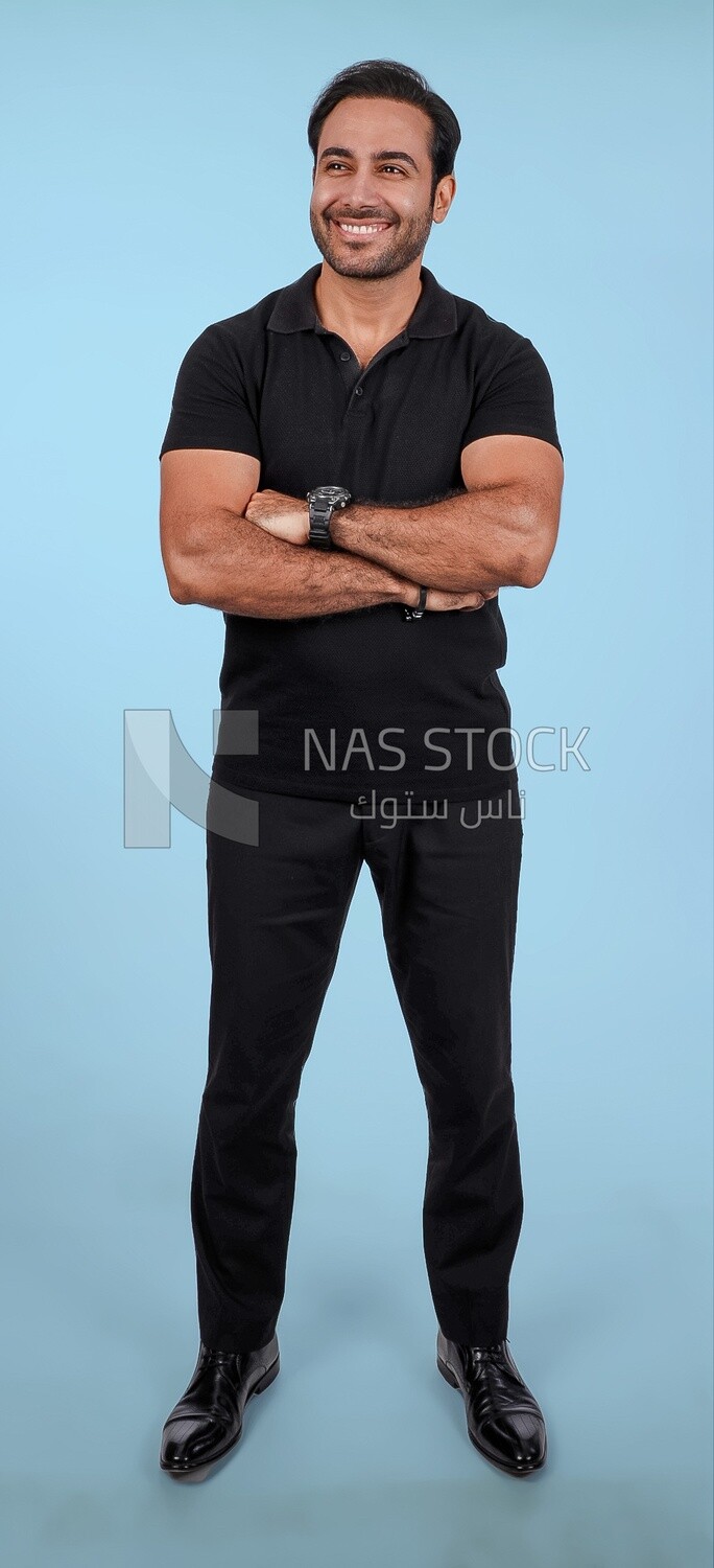 Photo Of a Handsome man Standing with crossed hands, Smiling Man, Wearing Casual Clothes Posing In a Light Room Interior, Smiling At the Camera