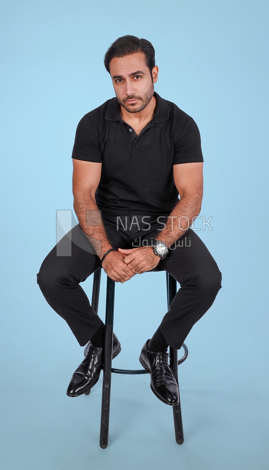Photo Of a Handsome man sitting on the chair, Smiling Man, Wearing Casual Clothes Posing In a Light Room Interior, Smiling At the Camera