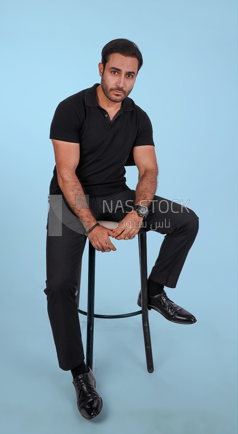 Photo Of a Handsome man sitting on the chair, Smiling Man, Wearing Casual Clothes Posing In a Light Room Interior, Smiling At the Camera