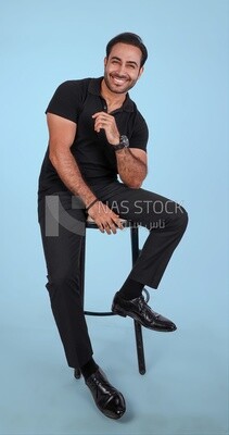Photo Of a Handsome man sitting on the chair, Smiling Man, Wearing Casual Clothes Posing In a Light Room Interior, Smiling At the Camera