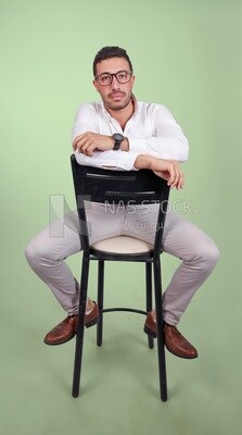 Photo of a handsome man with glasses sitting on a chair, business development and partnerships, business meeting, Model