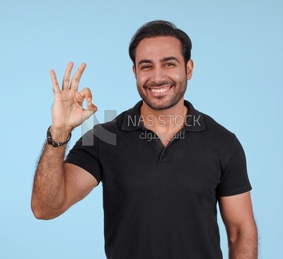 Photo Of a Handsome man Standing with hand gesture, Smiling Man, Wearing Casual Clothes Posing In a Light Room Interior, Smiling At the Camera