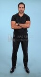 Photo Of a Handsome man Standing with crossed hands, Smiling Man, Wearing Casual Clothes Posing In a Light Room Interior, Smiling At the Camera