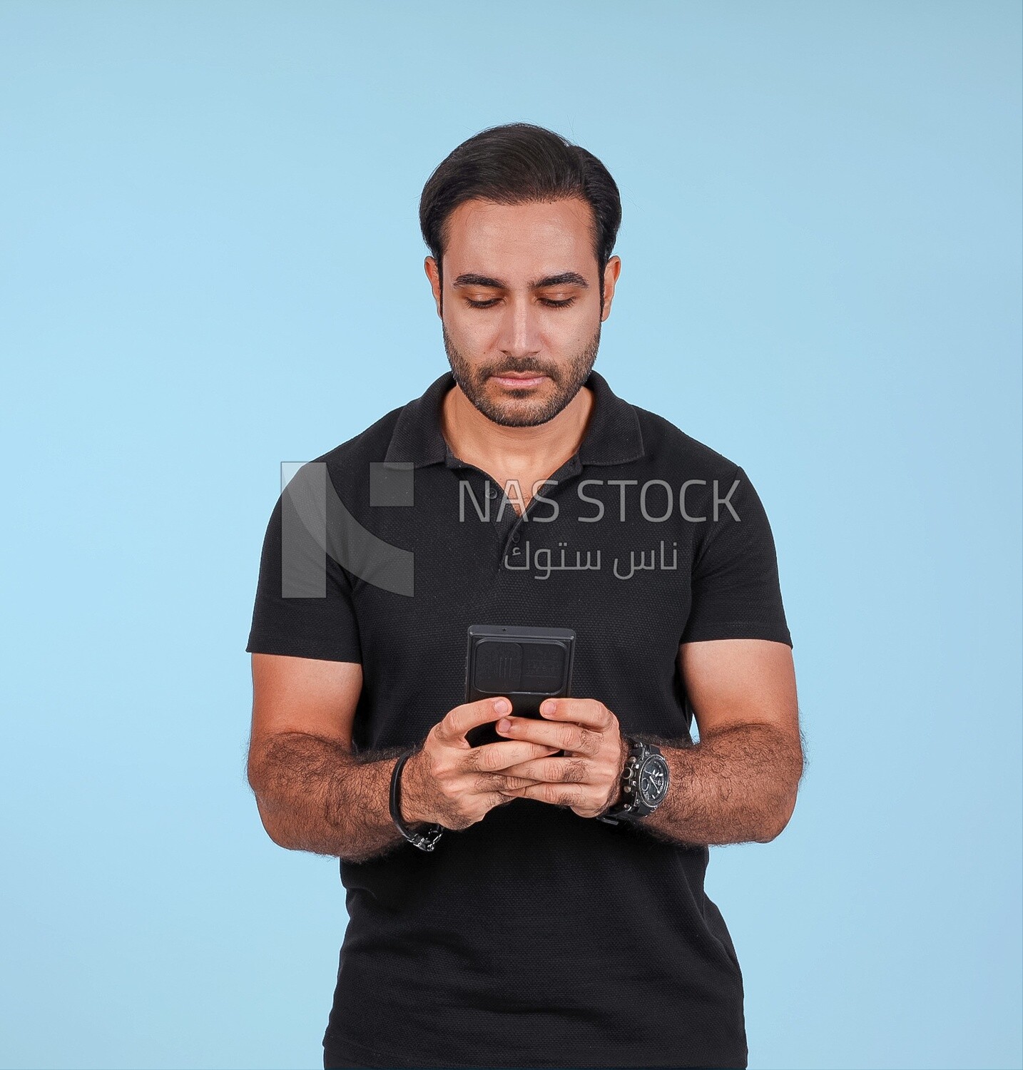 Photo Of a Handsome man Standing and holding his mobile, Smiling Man, Wearing Casual Clothes Posing In a Light Room Interior, Smiling At the Camera