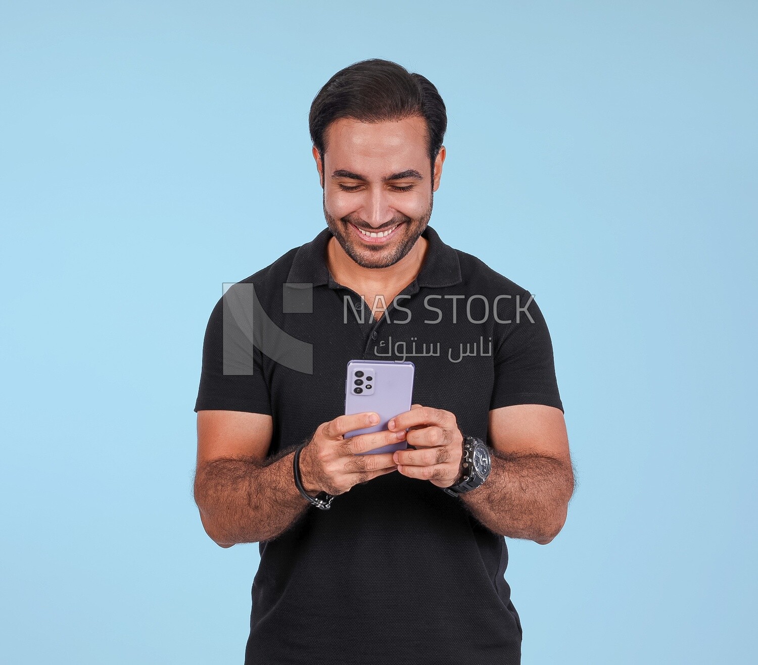 Photo Of a Handsome man Standing and holding his mobile, Smiling Man, Wearing Casual Clothes Posing In a Light Room Interior, Smiling At the Camera