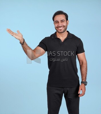 Photo Of a Handsome man Standing and pointing away, Smiling Man, Wearing Casual Clothes Posing In a Light Room Interior, Smiling At the Camera