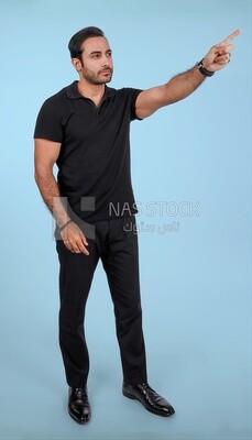 Photo Of a Handsome man Standing and pointing away, Smiling Man, Wearing Casual Clothes Posing In a Light Room Interior, Smiling At the Camera