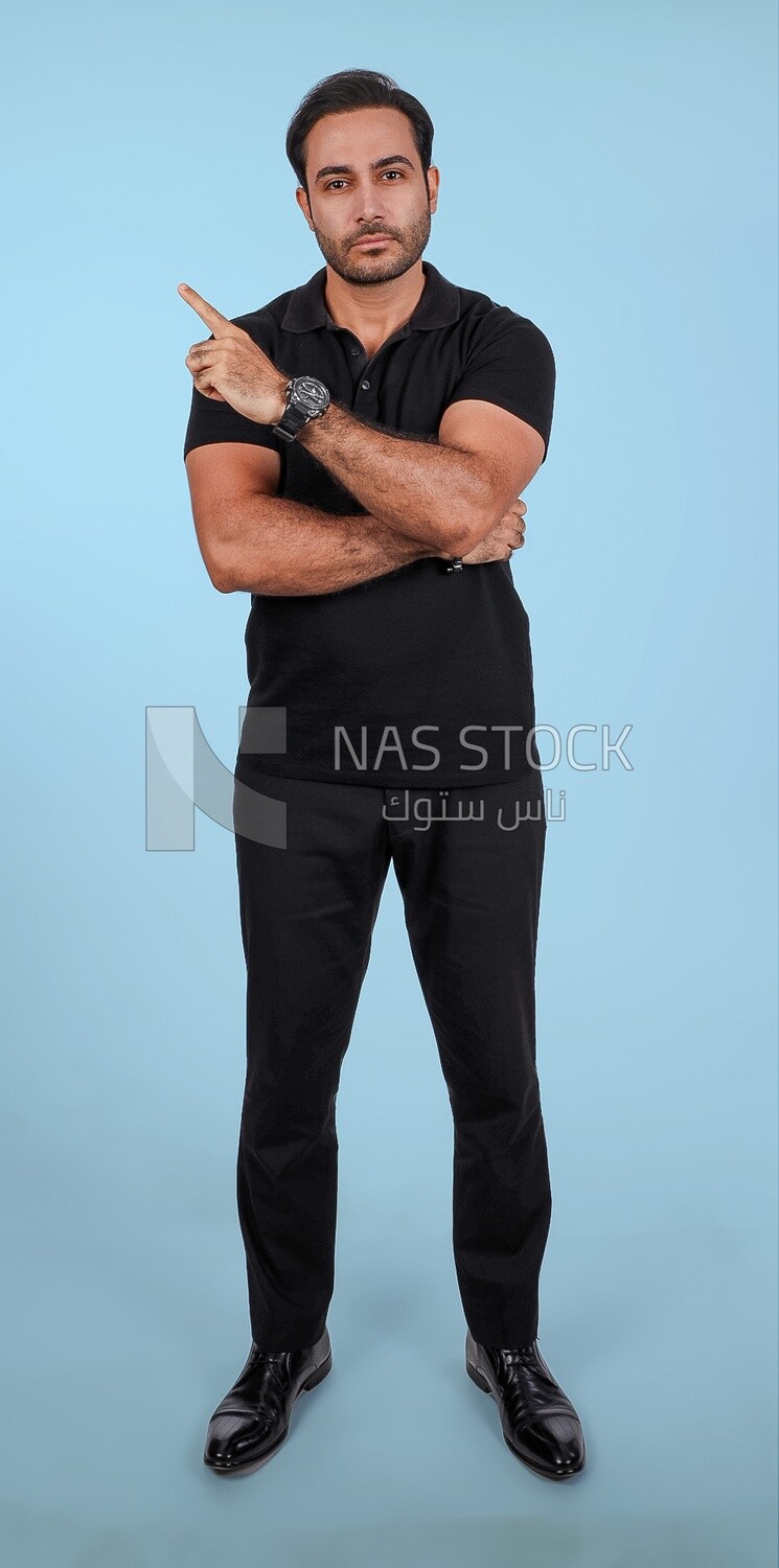 Photo Of a Handsome man Standing and pointing away, Smiling Man, Wearing Casual Clothes Posing In a Light Room Interior, Smiling At the Camera