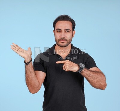 Photo Of a Handsome man Standing and pointing away, Smiling Man, Wearing Casual Clothes Posing In a Light Room Interior, Smiling At the Camera
