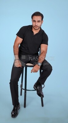 Photo Of a Handsome man sitting on the chair, Smiling Man, Wearing Casual Clothes Posing In a Light Room Interior, Smiling At the Camera