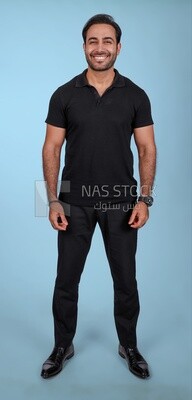 صورة لرجل وسيم يقف ، رجل مبتسم ، يرتدي ملابس غير رسمية ، يقف في داخل غرفة خفيفة ، ويبتسم للكاميرا
