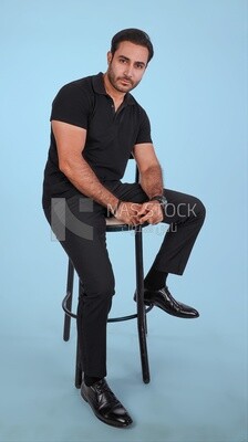 Photo Of a Handsome man sitting on the chair, Smiling Man, Wearing Casual Clothes Posing In a Light Room Interior, Smiling At the Camera