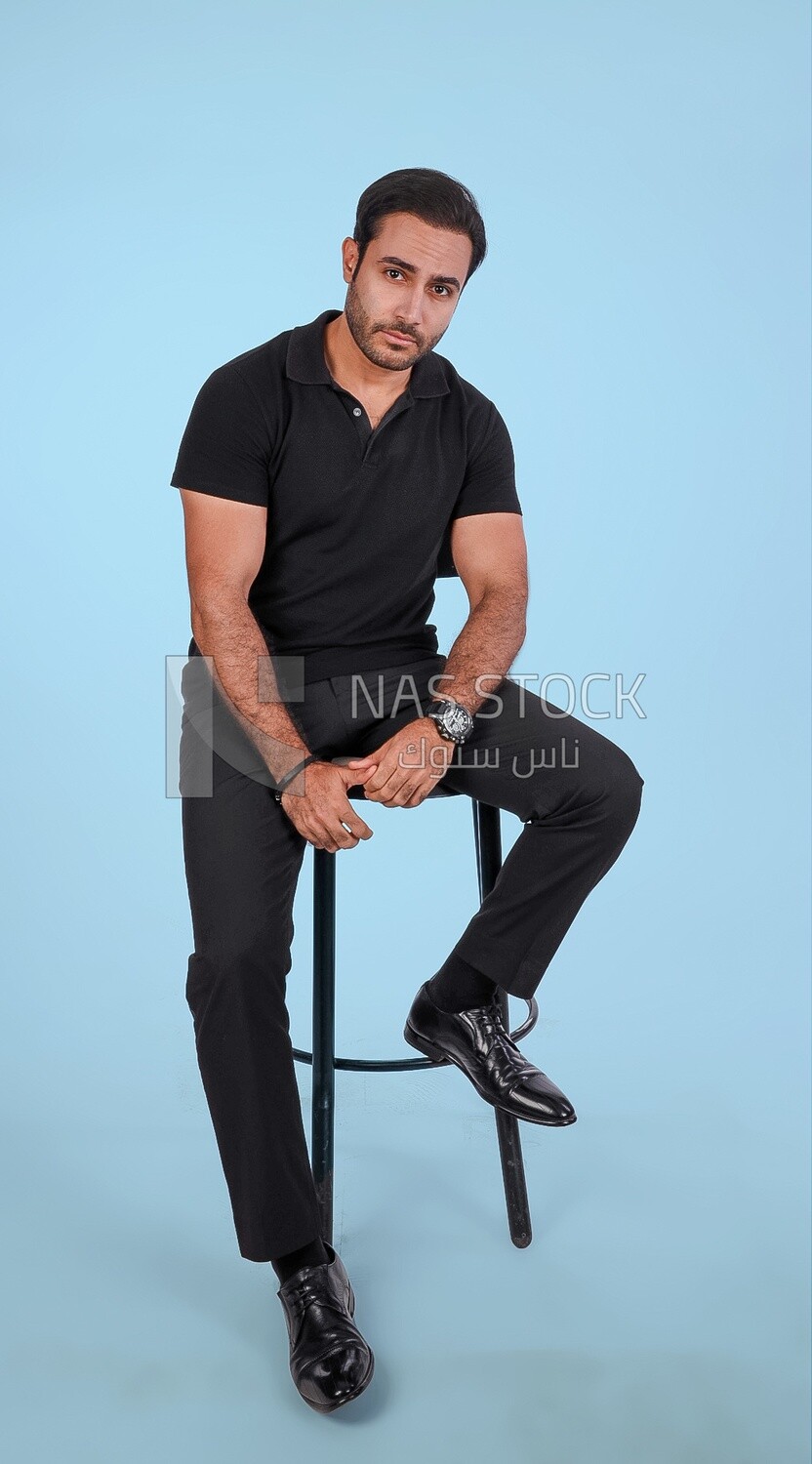 Photo Of a Handsome man sitting on the chair, Smiling Man, Wearing Casual Clothes Posing In a Light Room Interior, Smiling At the Camera