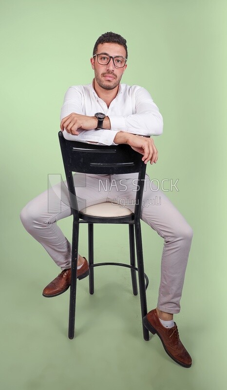 Photo of a handsome man with glasses sitting on a chair, business development and partnerships, business meeting, Model