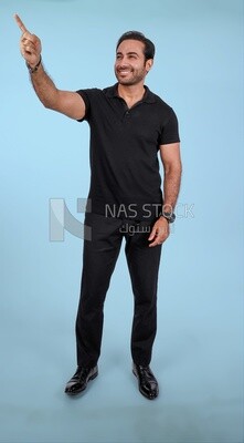Photo Of a Handsome man Standing and pointing away, Smiling Man, Wearing Casual Clothes Posing In a Light Room Interior, Smiling At the Camera
