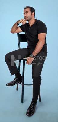 Photo Of a Handsome man sitting on the chair looks away, Smiling Man, Wearing Casual Clothes Posing In a Light Room Interior, Smiling At the Camera