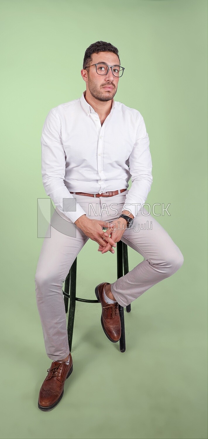 Photo of a handsome man with glasses sitting on a chair, business development and partnerships, business meeting, Model, looking away