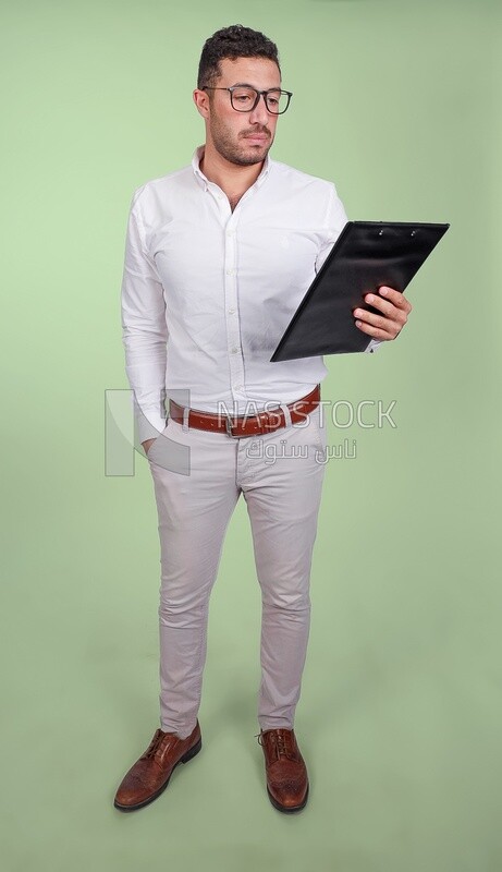 Photo of a handsome man with glasses and reading from a paper clipboard, business development and partnerships, business meeting, Model