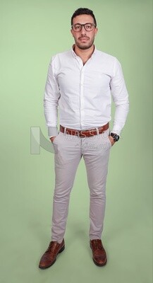 Photo of a handsome man standing and putting his hand in his pocket, a smiling man, dressed casually in an indoor light room, smiling at the camera, looking away