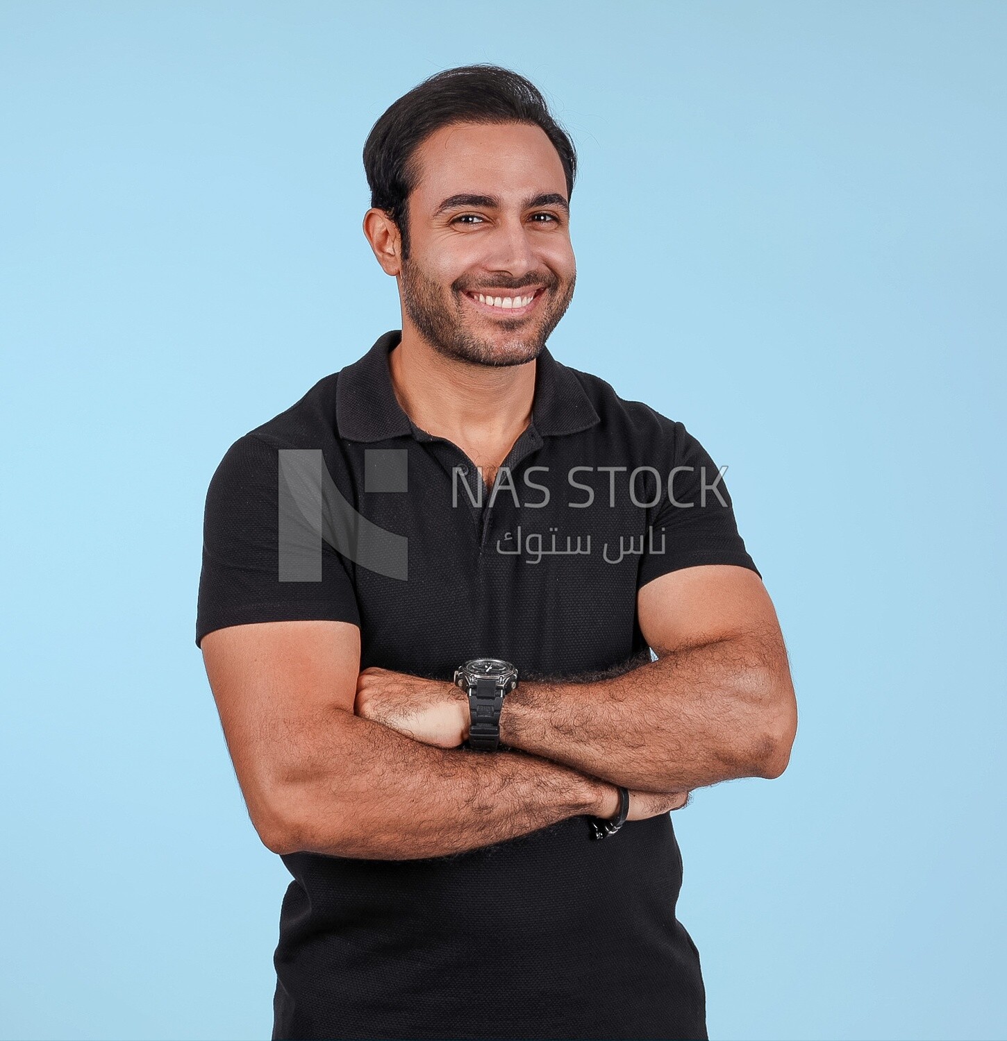 Photo Of a Handsome man Standing with crossed hands, Smiling Man, Wearing Casual Clothes Posing In a Light Room Interior, Smiling At the Camera