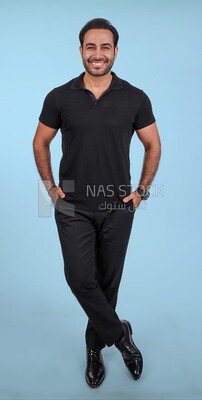Photo of a handsome man standing and putting his hand in his pocket, a smiling man, dressed casually in an indoor light room, smiling at the camera, looking away