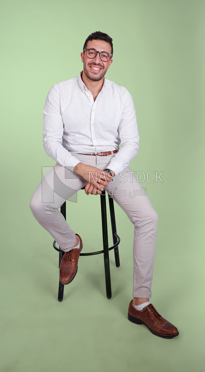 Photo of a handsome man with glasses sitting on a chair, business development and partnerships, business meeting, Model
