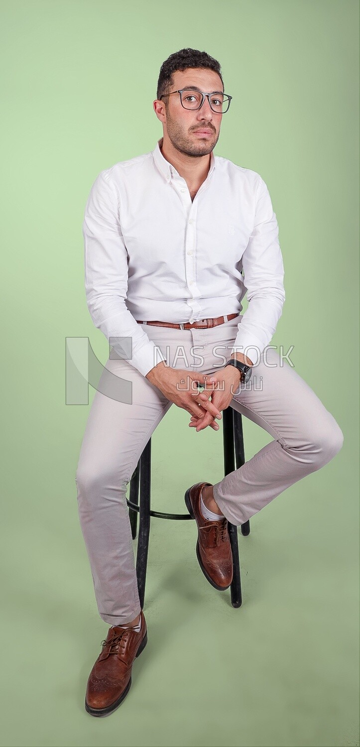 Photo of a handsome man with glasses sitting on a chair, business development and partnerships, business meeting, Model