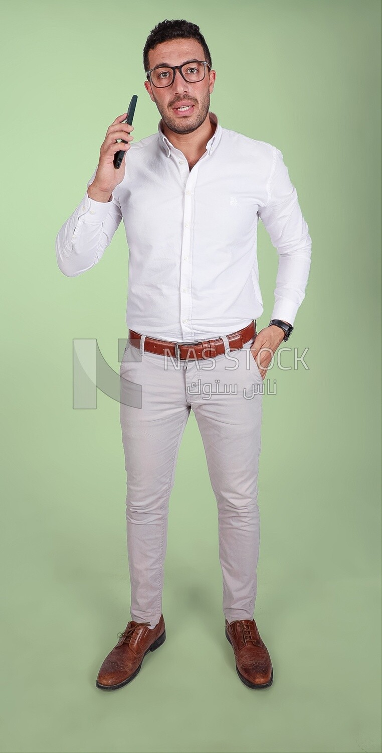 Photo of a handsome man wearing glasses standing and talking on the phone, business development and partnerships, business meeting, model