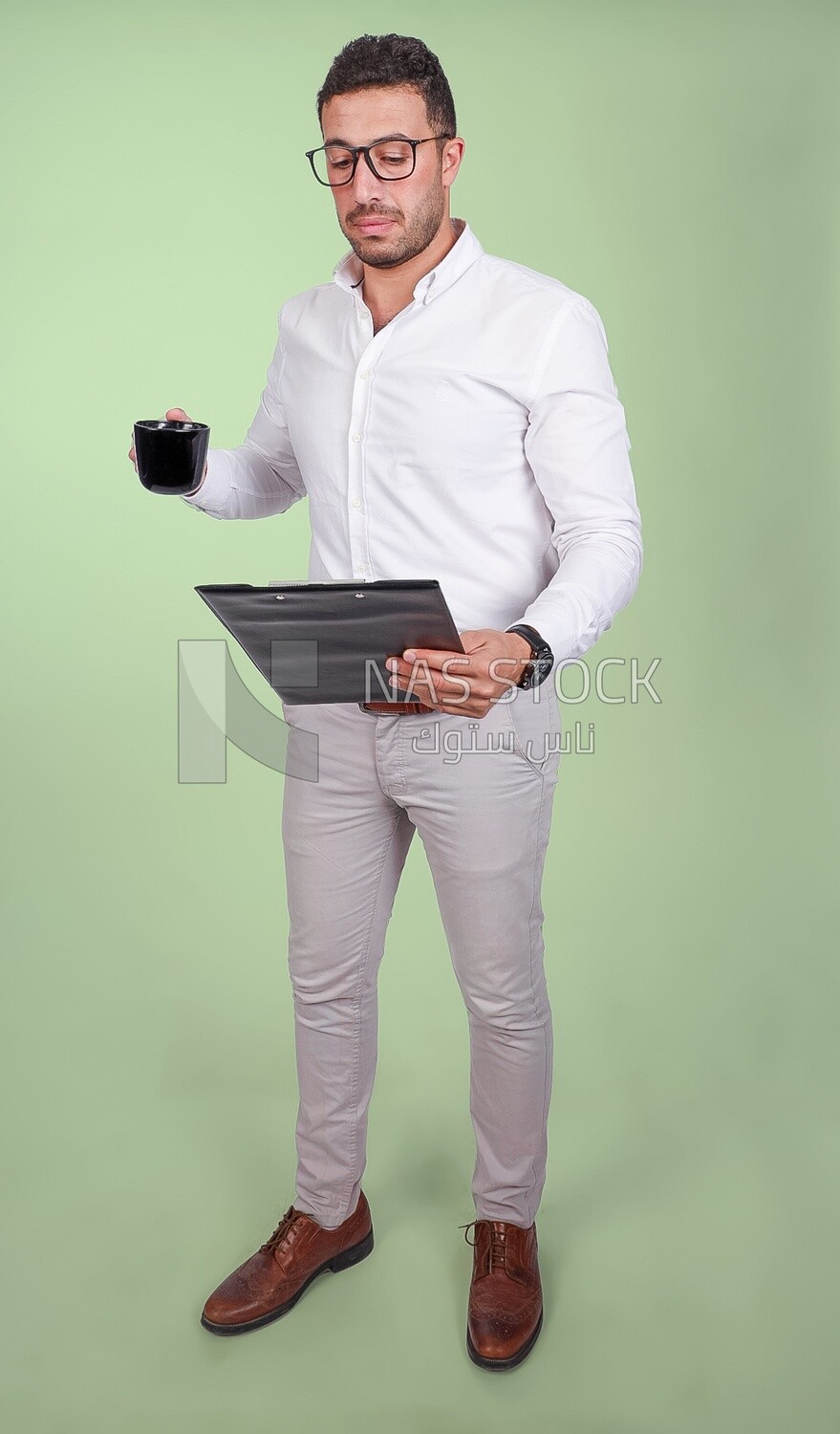 Photo of a handsome man with glasses and reading from a paper clipboard, drinking a coffee, business development and partnerships, business meeting, Model