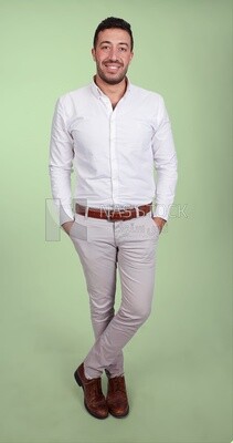 Photo of a handsome man standing and putting his hand in his pocket, a smiling man, dressed casually in an indoor light room, smiling at the camera, looking away