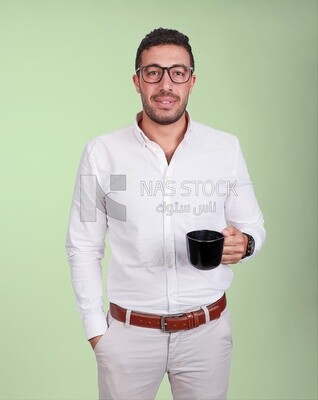 Photo of a handsome man wearing glasses standing holding a cup of coffee, business development and partnerships, business meeting, model