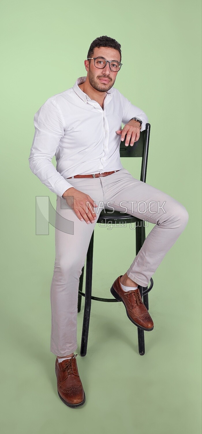 Photo of a handsome man with glasses sitting on a chair, business development and partnerships, business meeting, Model