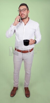 Photo of a handsome man wearing glasses standing talking on his phone and drinking coffee, business development and partnerships, business meeting, model