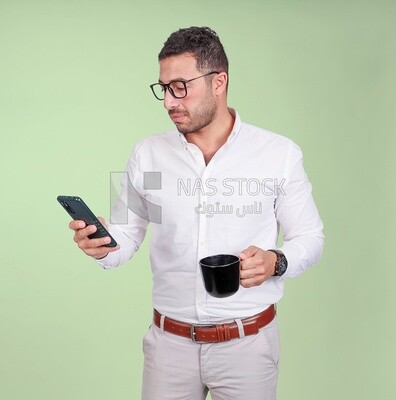 Photo of a handsome man wearing glasses standing and checking his phone, business development and partnerships, business meeting, model