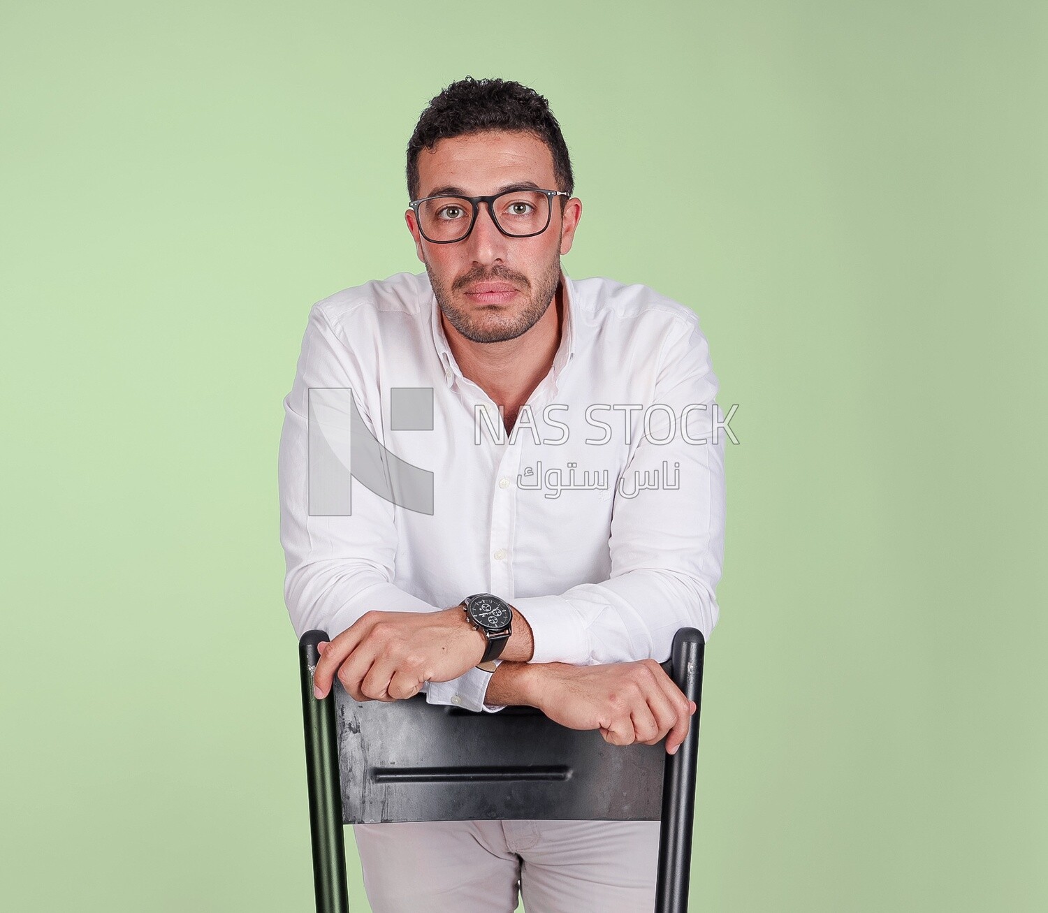 Photo of a handsome man wearing glasses standing and leaning on a chair, business development and partnerships, business meeting, model