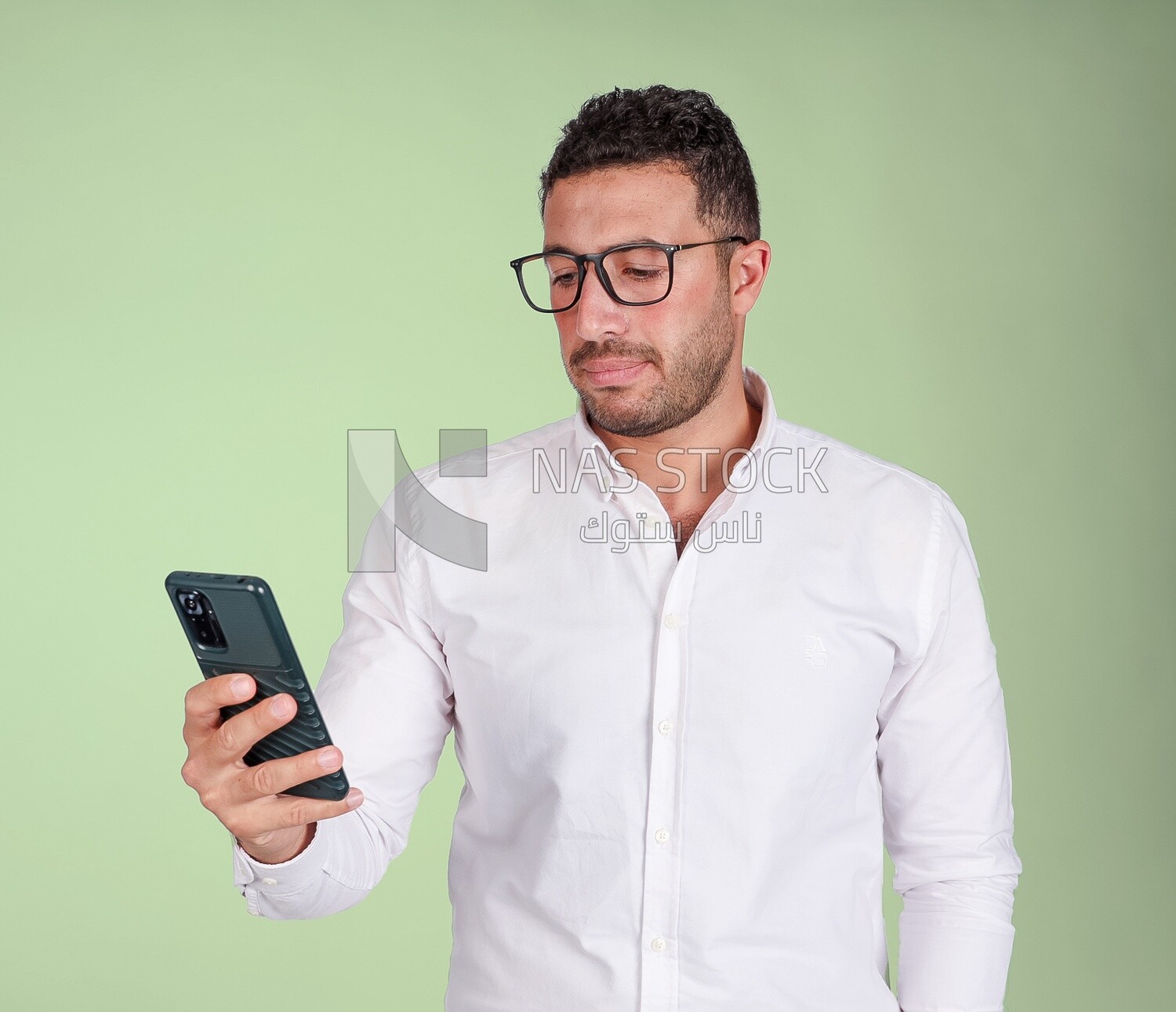 Photo of a handsome man wearing glasses standing and checking his phone, business development and partnerships, business meeting, model
