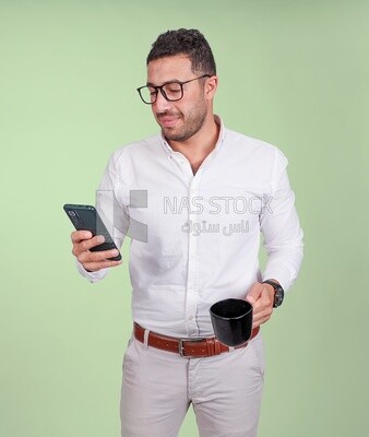 Photo of a handsome man wearing glasses standing and checking his phone, business development and partnerships, business meeting, model