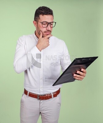 Photo of a handsome man with glasses and reading from a paper clipboard, business development and partnerships, business meeting, Model