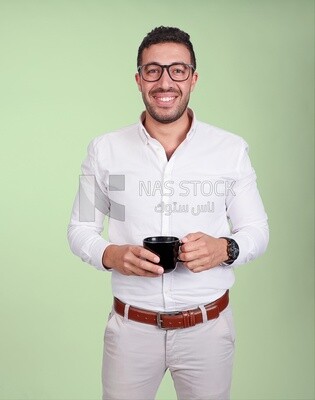 Photo of a handsome man wearing glasses and standing holding a cup of coffee, business development and partnerships, business meeting, model