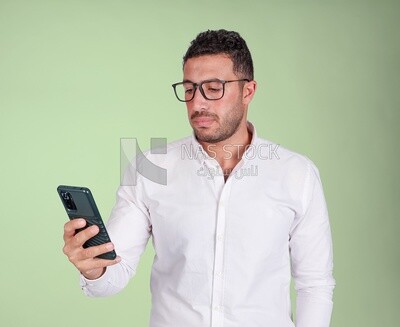Photo of a handsome man wearing glasses standing and checking his phone, business development and partnerships, business meeting, model