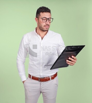 Photo of a handsome man with glasses and reading from a paper clipboard, business development and partnerships, business meeting, Model