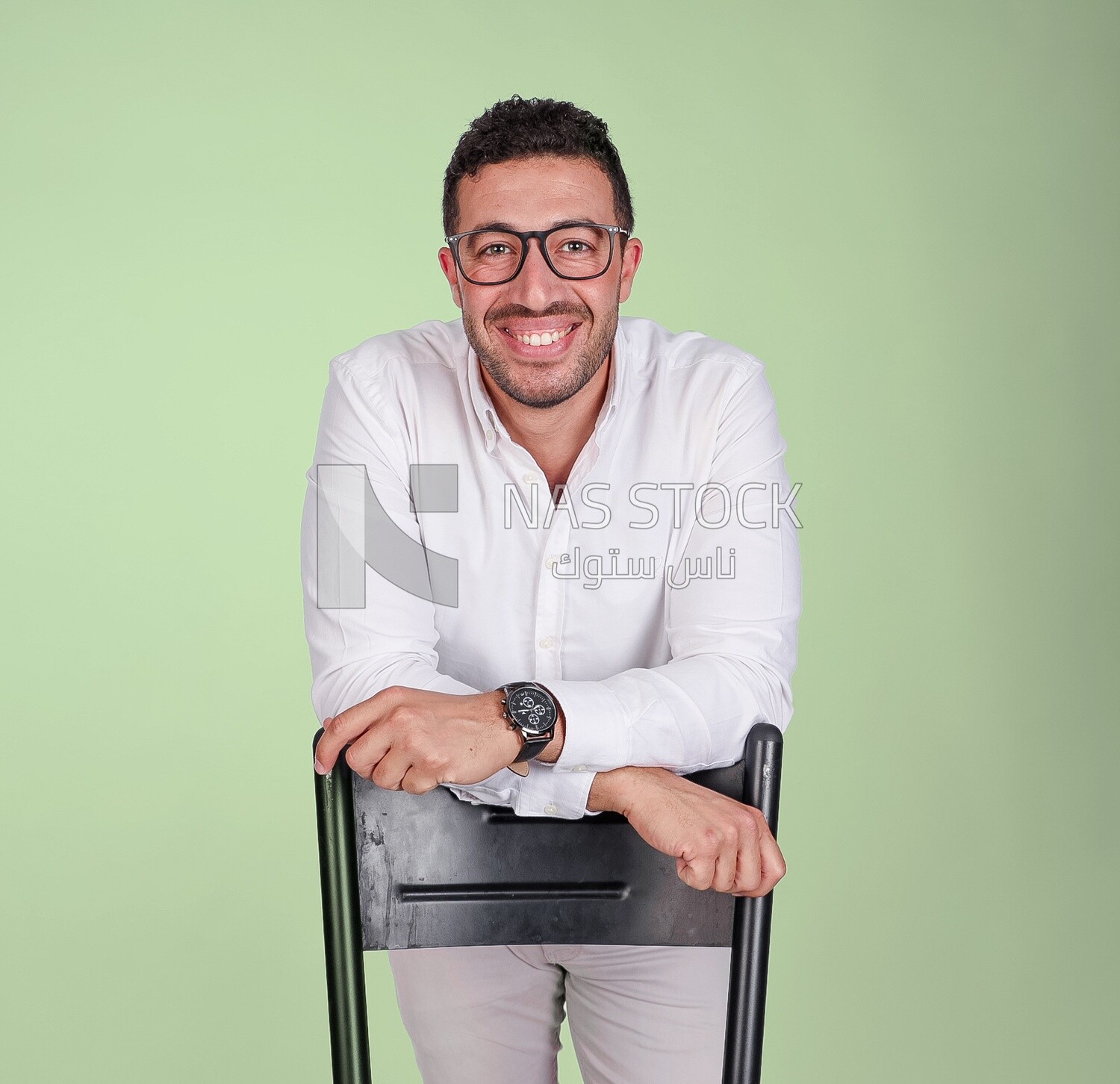 Photo of a handsome man wearing glasses standing and leaning on a chair, business development and partnerships, business meeting, model