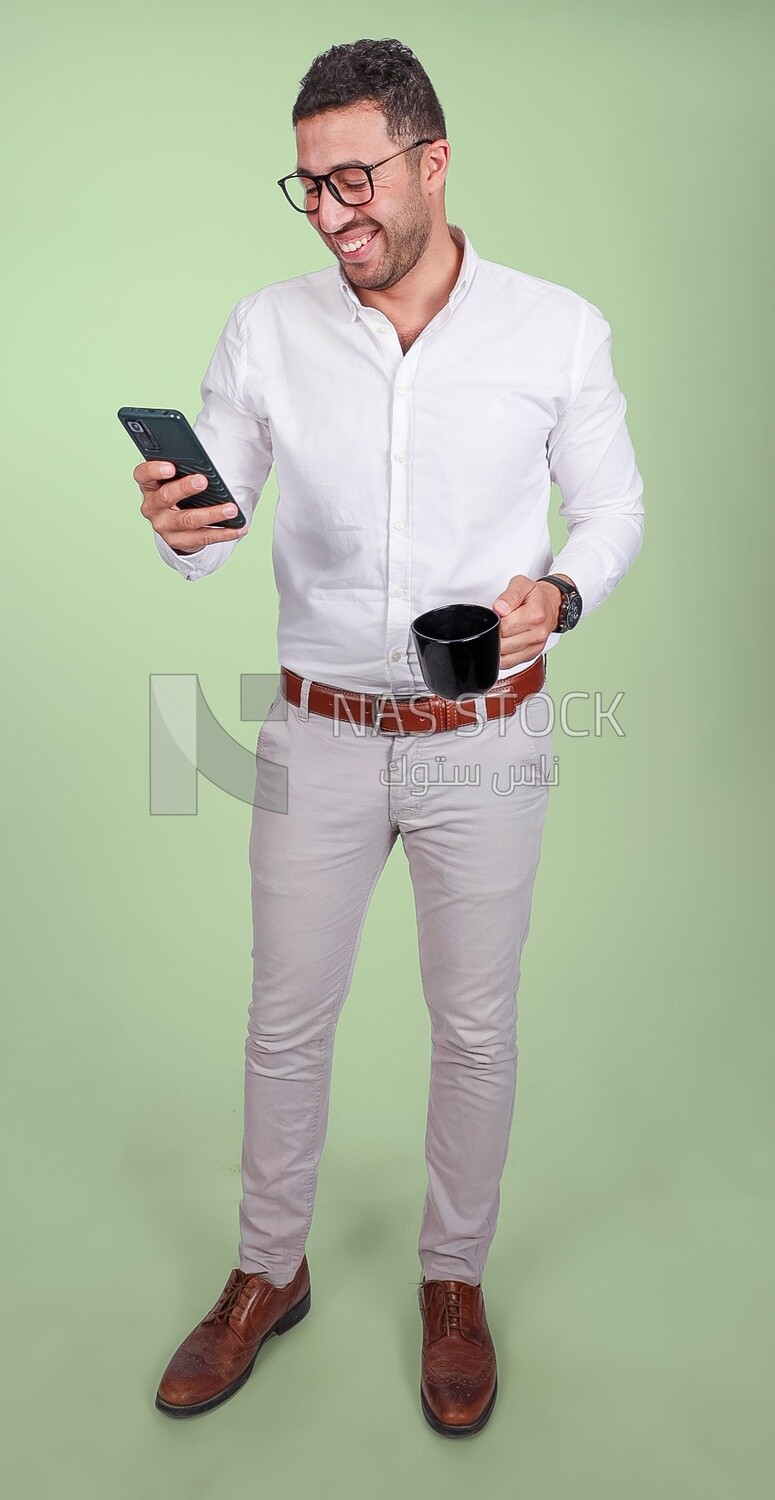 Photo of a handsome man wearing glasses standing and checking his phone, business development and partnerships, business meeting, model