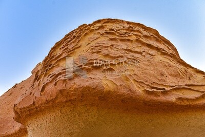A scene of rock formations on a sandy mountain in the Wadi El Hitan desert in Egypt