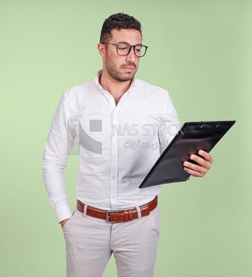صورة لرجل وسيم يرتدي نظارات ويقرأ من حافظة ورقية ، تطوير الأعمال والشراكات ، اجتماع عمل ، موديل